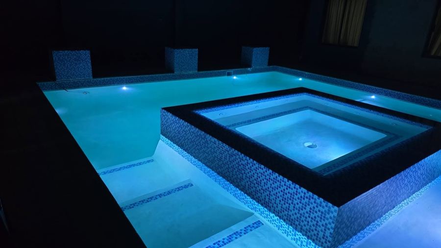 The same pool renovation completed, lit and filled with water at night