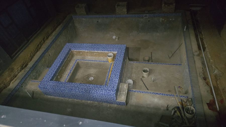 A pool renovation project mid-construction, tiling and concrete work in progress